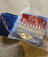 Two sealed tarps in original package with one unfolded tarp