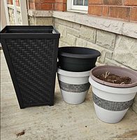 Three planters grouped: tall black square and two round white/grey