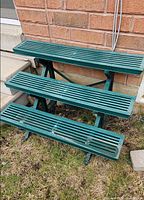 three-tier green plastic plant stand outdoors