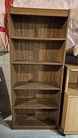 Front view of brown laminate bookcase with five shelves