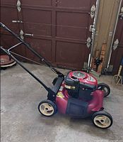 Side view of red Craftsman mower showing handle and wheels