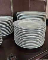 Stacked bread & butter size plates and dinner plates showing floral rim pattern