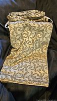 Folded duvet cover showing gold side with green damask