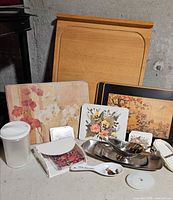 Group shot shows cutting board, placemats, coaster, plastic canister, napkin holder, stainless items, spoon and rest