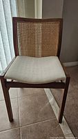 Front view of wood chair with cane back and cream seat