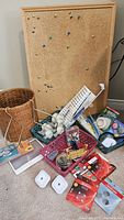Overall view of lot contents on floor: bulletin board, baskets, batteries, supplies