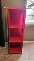 Front view of red fabric shelving unit with three shelves