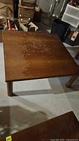 Top view of square solid wood coffee table showing finish wear