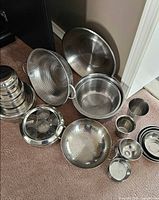 All stainless steel items displayed on floor showing variety and count