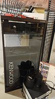 Kenwood cabinet with glass door, interior shelves, items in front