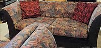 Front view of patterned loveseat with red swirl pillows