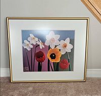 full view of framed floral print standing against wall