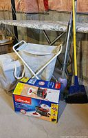 Boxed Vileda mop set, two hampers, broom visible
