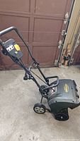 Full side view of Yardworks electric snow thrower showing handle, wheels and auger housing