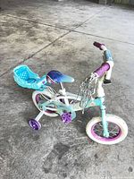 Left side view of Frozen bicycle showing frame, training wheels, rear carrier