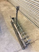 Top angled view showing full frame, vertical hitch arm, rotating tine shaft