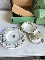 Place setting pieces displayed: dinner plate, salad plate, bowl, cup, saucer