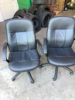 Front view of both black faux leather office chairs