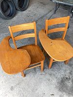 Top view of both wooden desk chairs showing attached tablets and overall condition