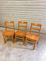 Front view of three oak toddler chairs side by side
