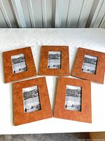 Five tan faux leather picture frames displayed front view