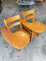 Two wooden student chairs with tablets shown together