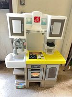 Front view of Step2 play kitchen showing sink, stovetop, oven and cabinets