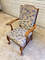 Front angle of armchair showing upholstery, arms, legs