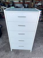 Front view of white five-drawer cabinet with glass top