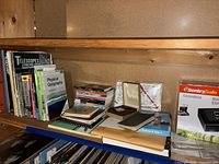 Shelf with books, pocket guides, compass case, CDs, navigation tools