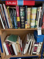 Shelf with top row of assorted cookbooks and Life.doc binder