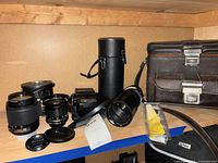 Group shot of all lenses, flash, cases, bag and accessories on shelf