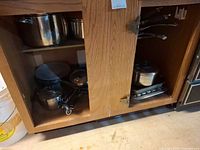 Cabinet showing multiple pots, pans and roasting pan