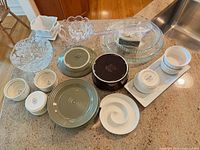Overview of all dishes, ramekins, plates, glass bowls and platter on countertop