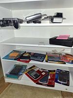 Shelf view showing multiple calculators in packaging and cassette recorder