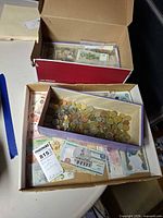 Open boxes showing tray of mixed coins and loose foreign banknotes