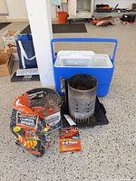 Entire lot with cooler, charcoal bag, chimney starter, grill wipes, small grill grate visible