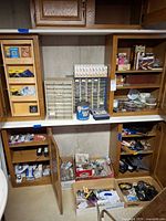 Overall view of cabinets filled with organizers, hardware, tapes, padlocks on floor