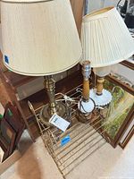 Overall view of two lamps with shades, third lamp base and metal stand