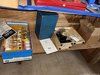 Shelf showing chemistry set box, Tasco case, wooden slide box and Pyrex carton