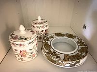 Two lidded Minton vanity dishes and Imari-style ashtray displayed on shelf