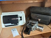 Two movie cameras side-by-side with carrying case