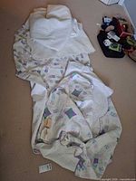 Quilts laid on carpet showing patterns, stitching and visible wear