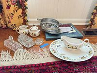 Group shot of all Royal Doulton china pieces, silver-plate items, and glass butter dishes