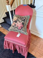 Full view of striped upholstered chair with pillow on seat