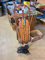 Front view of Flying Arrow sled standing upright with ice skates at base