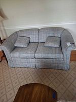Front view of plaid Stanton Cooper loveseat with two pillows