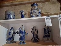 All seven stoneware pieces on shelf: crock and six figurines