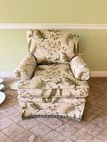 Front view of upholstered armchair showing pattern, cushions, skirt