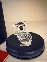 Front view of clear Swarovski crystal koala on blue base